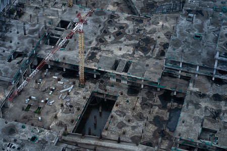 未竣工楼层雨后大型建筑物的建筑工地的最顶端 管道被开进 下面的楼层被建造财产工程师起重机进步材料头盔机器商业脚手架天线背景