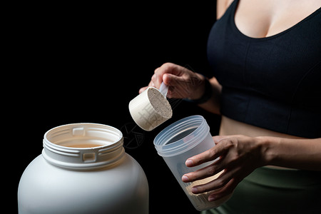 获得者近距离接近妇女 测量一勺蛋白质 罐子和营养女性健美肌肉饮食养分乳清粉末摇床活力背景
