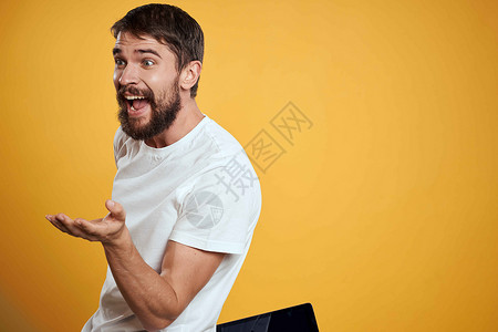 在白色T恤衫上用黄色背景的平板牌男子 商务人士触摸屏幕触摸板的新科技互联网工作室办公室衬衫工作商业触摸屏快乐药片电脑背景图片
