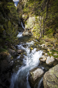 湿谷在阳光明媚的白天 岩石之间的小小溪流动瀑布场景溪流液体速度石头环境日落海浪背景