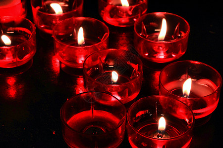 在教堂祈祷点燃红蜡烛宗教火焰精神花圈桌子传统团体装饰品云杉烧伤背景图片