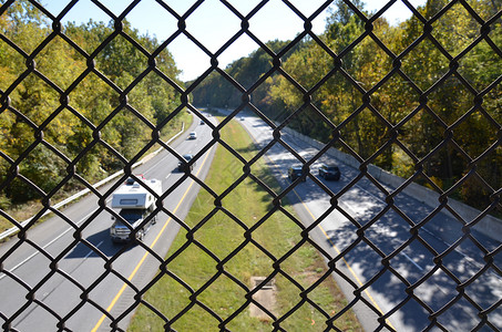 公路或有汽车的公路上的金属围栏击剑运输链环道路街道背景图片