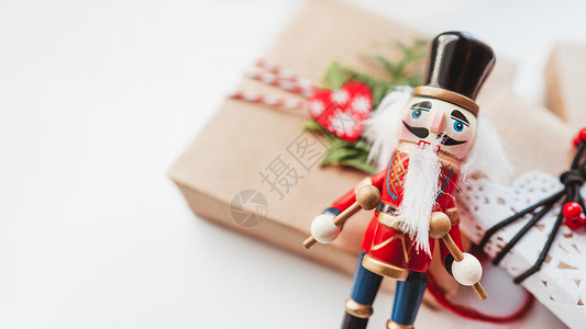 小夹子素材用牛皮纸和木制胡桃夹子玩具包裹的圣诞 DIY 礼物 新年礼物上的装饰 节日背景 寒假精神 与复制空间的白色背景背景