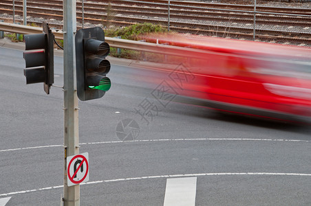 红绿灯灯杆使用绿色交通灯杆移动模糊的红色汽车背景