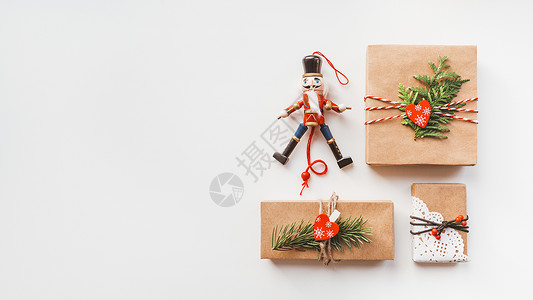 胡桃夹子玩具圣诞DIY礼物包装在手工艺纸和木制胡桃背景
