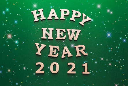 新年文字海报2021 年新年快乐庆祝活动 2021 年的木制字母和数字 戴着新年帽 背景是绿色的 有雪 具有顶视图和复制空间的假日装饰或明信背景