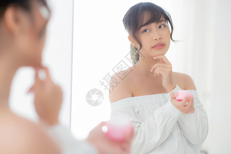 美丽的肖像 年轻的年轻女性 使用奶油润湿剂洗剂温泉反射女孩保湿弹性镜子化妆品润肤治疗背景图片