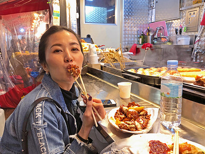 不怕吃苦年轻女性在S区吃苦饼干韩国炸鸡街食品背景