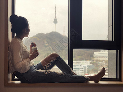 一眼望三川年轻女孩喝咖啡 望着窗外看一眼背景