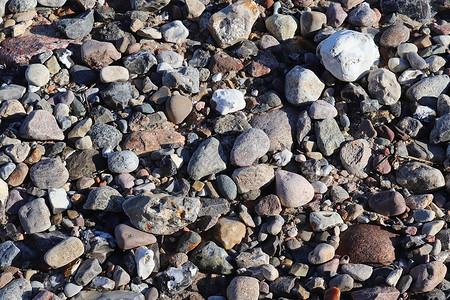 美丽的石头石块碎片 在无海平面的海滩上花岗岩海洋材料岩石宏观鹅卵石矿物团体地面支撑背景图片