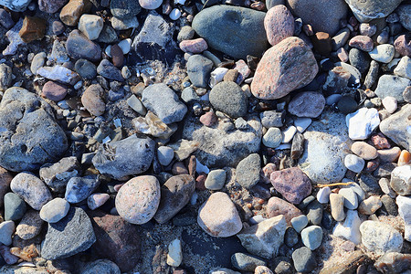 美丽的石头石块碎片 在无海平面的海滩上矿物团体宏观地面海洋碎石岩石海岸鹅卵石材料背景图片