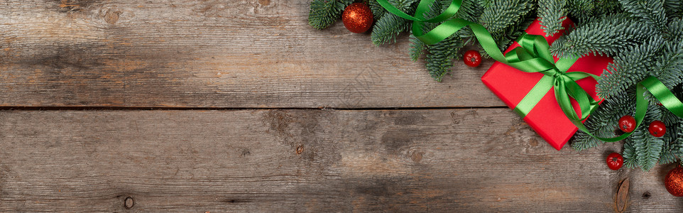 圣诞宣传单圣诞礼物和fir 树枝框架高架乡村玩具新年木头金子礼物丝带卡片背景