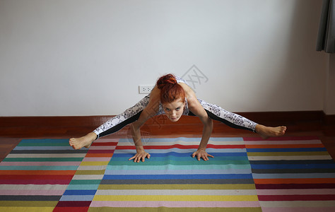 规律运动妇女在家里做瑜伽冥想训练女士运动灵活性运动装练习身体女孩地面背景