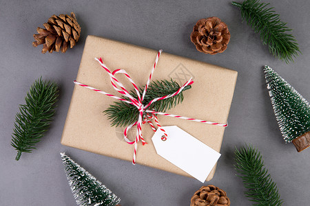 圣诞标签圣诞假期组合物 礼品盒有标签装饰 新年和圣诞节或周年纪念 礼物在水泥地板背景上有标签 在季节 顶视图或平躺 复制空间手工松果牛皮背景