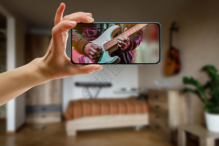 吉他教师在屏幕上接听音乐课 在家中通过手机提供在线音乐课程频率视频钢琴家电影教程乐器青少年互联网电话播客背景图片