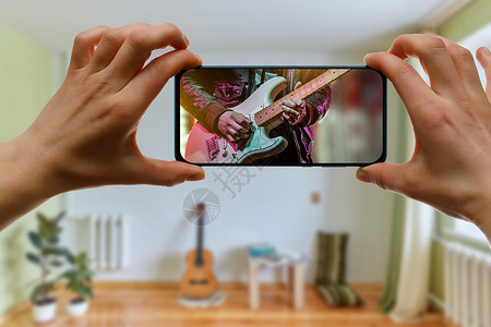 吉他教师在屏幕上接听音乐课 在家中通过手机提供在线音乐课程音乐家乐器记录电影店铺国家房间教程视频电话背景图片