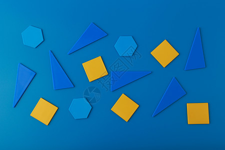 黄色几何三角形蓝色背景上有蓝色和黄色几何图形的平躺背景