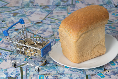 人道主义的哈萨克斯坦坚戈 KZT 放在杂货篮里 里面有面包 哈萨克斯坦和其他国家的食品和杂货价格上涨 人道主义援助粮食危机救援营销熟食金融背景