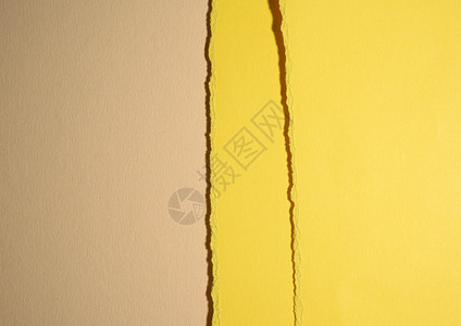 带阴影的米色背景抽象背景上黄色纸板撕裂的边缘宏观床单框架损害工艺空白背景图片