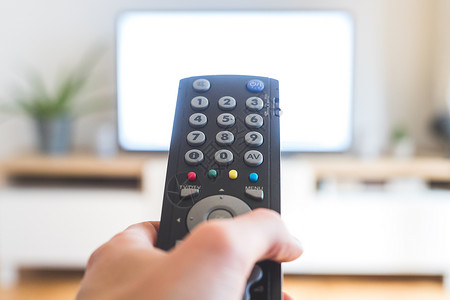 按钮素材高清男性手握着电视遥控器 在智能电视上流传视频房间影院电影溪流程序家庭屏幕遥控手指背景