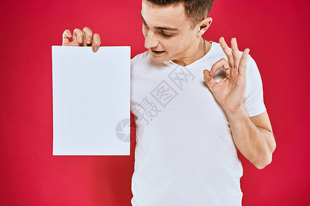 T恤海报持有纸质复制空间T恤红色背景材料的情绪型男子成人广告牌卡片男人商业男性横幅微笑办公室快乐背景
