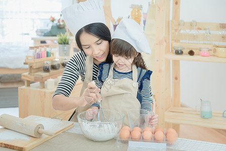 母亲做的饭亚裔母亲和女儿正在准备钱 在度假时在厨房做蛋糕 然后在饭室做蛋糕婴儿帮助假期享受乐趣帮手家庭女孩快乐幸福背景