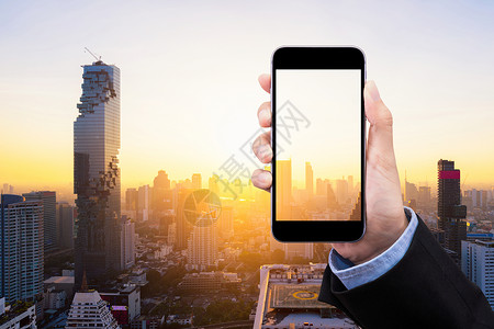手机注册界面女商务人士在背景中展示带有透明屏幕和智能城市复制空间的智能手机 优雅的商业和智慧城市概念设计背景
