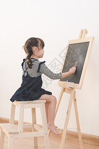 漫画黑板素材快乐的亚洲女孩在黑板上用粉笔画漫画 在家里学习学生写作绘画教育刷子知识艺术学校幼儿园微笑背景