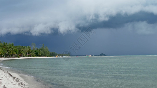 热带气旋在潮湿的雨季 泰国苏梅岛的沙质海岸挥舞着蓝色的大海 异国情调的热带海洋海滩上的飓风和风暴警告 疾风不祥云 危险台风雷暴海景气旋天背景