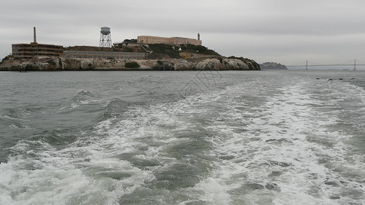 美国加利福尼亚州旧金山湾的恶魔岛 在岩石上关押歹徒的联邦监狱 多雾的天气 历史悠久的监狱 迷雾笼罩的海港悬崖 犯罪入狱监禁旅游空背景图片