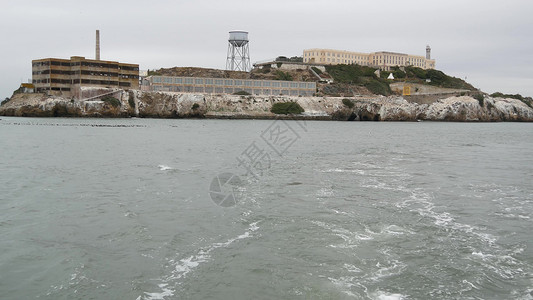 美国加利福尼亚州旧金山湾的恶魔岛 在岩石上关押歹徒的联邦监狱 多雾的天气 历史悠久的监狱 迷雾笼罩的海港悬崖 犯罪入狱监禁地标湿背景图片