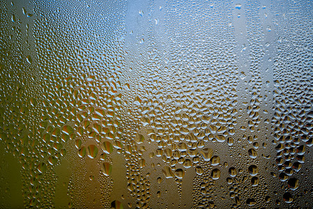 玻璃杯或瓶子外面结露宏观滴水天气雨滴环境蓝色水滴气泡飞沫窗户背景