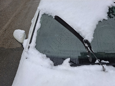 在一辆被雪覆盖的汽车前 提升了屏幕擦拭器高清图片