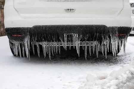 来回冰雪覆盖的汽车保险杠与冰柱特写 欧洲冻雨后的车辆停车安全白色气候温度降雪风暴危险场景季节灾难交通背景