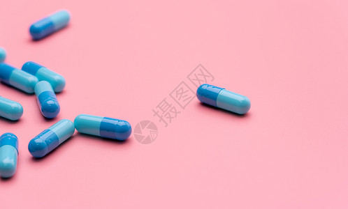 粉红色背景上的蓝色胶囊药丸 在线药房概念 药房横幅 医药行业 女性概念的健康预算和保险 治疗乳腺癌的药物研究背景图片