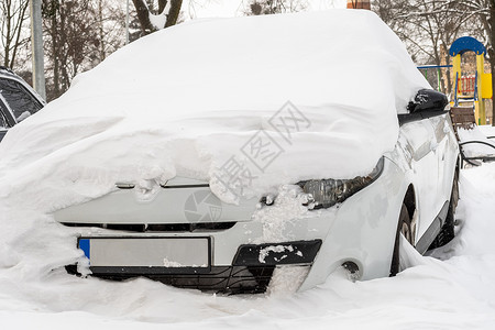 暴风雪过后的城市街道 汽车被困在冰雪之下 车辆被埋在路上的雪堆中 冬天大雪过后的停车场 未清洁的道路 破纪录的降雪量冻结街道城市背景