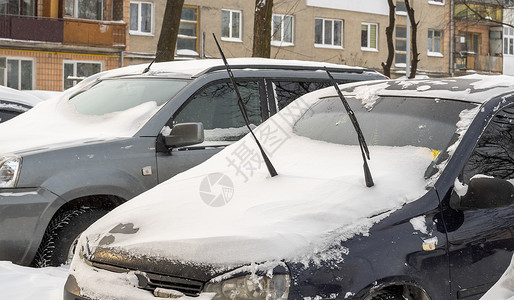 暴风雪过后的城市街道 汽车被困在冰雪之下 车辆被埋在路上的雪堆中 冬天大雪过后的停车场 未清洁的道路 破纪录的降雪量城市街道危险背景