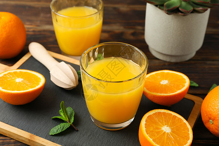 切板橙汁木榨汁机橙管和多汁植物木桌特写 新鲜的天然饮料和水果背景图片