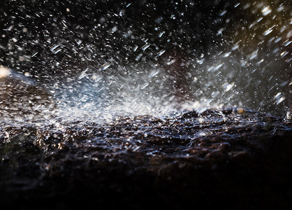 飞溅石头雨水滴落到石头上黄色天气季节黑色岩石雨滴水坑花岗岩下雨液体背景