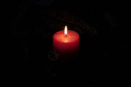 带有红色燃烧蜡烛和深色背景的圣诞主题背景图片