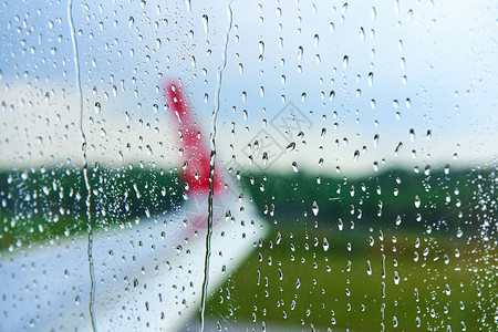 雨天飞机在雨天起飞前透过飞机雾蒙蒙的玻璃观看翅膀水滴蓝色航空公司雨滴旅行车辆天气喷射倾盆大雨背景