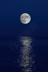 满月反射在晚上的海中 在西班牙科斯塔布拉瓦背景图片