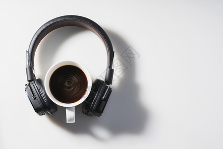 白色背景的耳机和咖啡杯背景图片