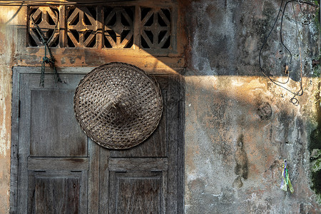 编织斗笠妇人中国草帽挂在特写的旧木窗上背景