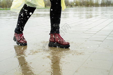 女人在雨中玩耍 在水坑里跳城市赛跑者天气沥青飞溅速度乐趣运动员运动行动图片