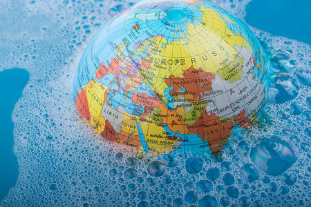 与泡沫一起漂浮在水中的小地球旅行游泳工作指导世界行星全球背景图片