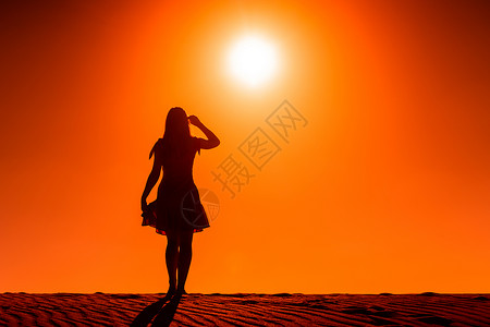 太阳无情地照耀着站在沙漠中的一个女人高清图片