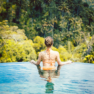 在热带度假中 享受游泳池丛林生活的女人太阳比基尼旅行游泳女士水池热带女孩风景假期背景图片