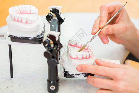 制假牙的牙科技术员作坊牙医矫正生产办公室女性女士烙印卫生工作背景