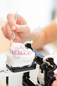 制假牙的牙科技术员医生工作牙齿女性生产象牙水泥牙科技师实验室女士背景